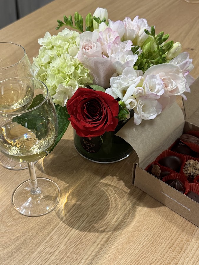 Elegant floral arrangement with wine and chocolates